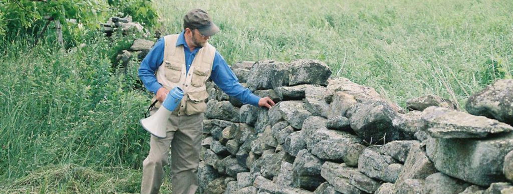 Thorson standing next to a stone wall.
