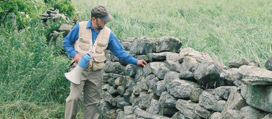 Thorson standing next to a stone wall.